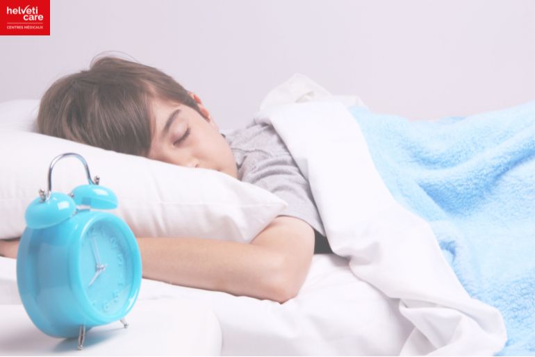 enfant qui dort avec un réveil